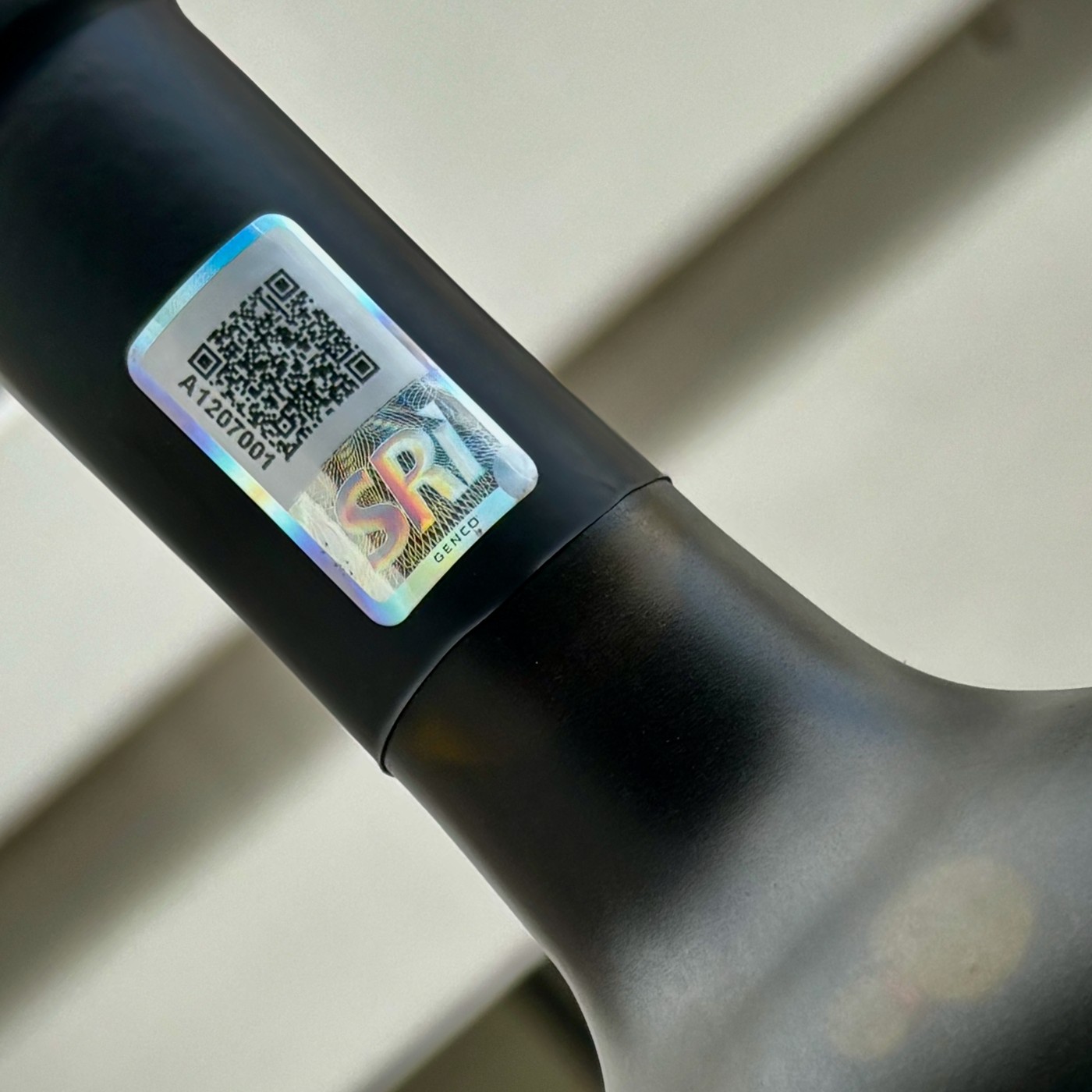 Timbre fiscal GENCO con código QR aplicado en el cuello de una botella